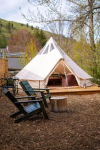ein weißes Zelt mit einer Bank und einem Tisch in der Unterkunft Creek-side Retreat - Glamping in The Dalles