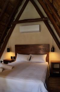 une chambre avec un grand lit blanc dans un grenier dans l'établissement Kaaj Ndomi, à Bacalar