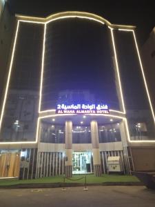 een groot gebouw met 's nachts een bord bij فندق الواحة الماسية 2 in Quai