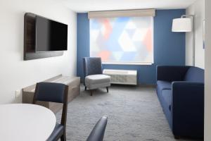 un salon avec un canapé et une télévision dans l'établissement Holiday Inn Express - Ludlow - Chicopee Area by IHG, à Ludlow