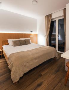 克拉尼斯卡戈拉Podlipnik Apartments的一间卧室配有一张大床,铺有木地板