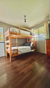 2 stapelbedden in een kamer met een houten vloer bij Hostal Casa Lavanda in Chillán