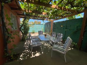 een terras met een tafel en stoelen onder een pergola bij Hostal Casa Lavanda in Chillán