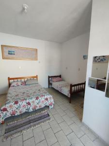 - une chambre avec un lit, une table et un lit sidx sidx sidx dans l'établissement Suite Penha SC, à Penha