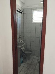 une salle de bains avec toilettes et lavabo dans l'établissement Suite Penha SC, à Penha