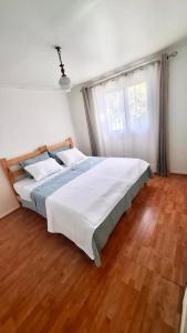 een slaapkamer met een groot bed met een houten vloer bij Hostal Casa Lavanda in Chillán