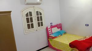 a small bedroom with a bed and a window at bayt in ‘Izbat Tall Abū Nārūz