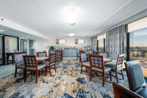 una sala da pranzo con tavoli, sedie e un bar di MCM Elegante Hotel a Odessa