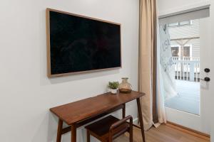 un tavolo in una stanza con un dipinto sul muro di The Optimist Guesthouse | 4 a Camden Altre 6 foto