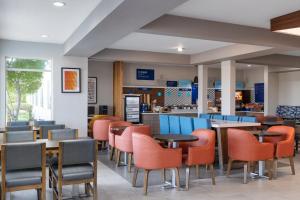 Holiday Inn Express Redding North by IHG في ريدينغ: مطعم به طاولات وكراسي ومنضدة