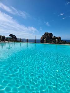 a pool of blue water with rocks in the background at Aligia Chalet in Nebida