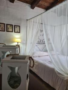 a bedroom with a bed with a white curtain at Aligia Chalet in Nebida +23 photos