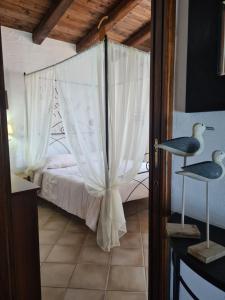 a bedroom with a bed with white curtains at Aligia Chalet in Nebida +43 photos