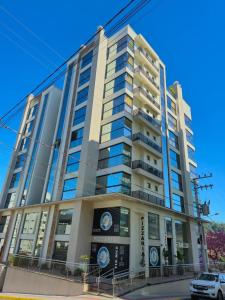 een hoog gebouw met een auto ervoor geparkeerd bij Ap Novo 303! Villa Premium in Piratuba