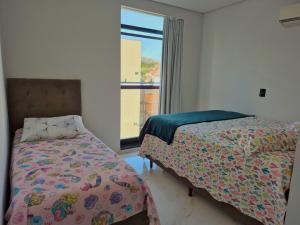 een slaapkamer met twee bedden en een raam bij Ap Novo 303! Villa Premium in Piratuba +11 foto's