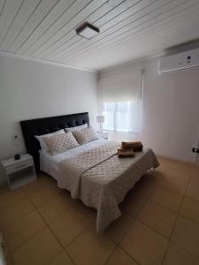 una camera da letto con un letto grande in una stanza bianca di Luluk, Casa de playa a Balneario Pehuén-Có
