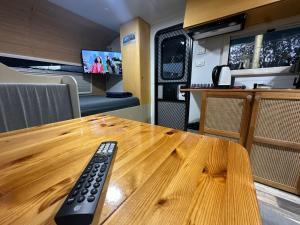 a remote control sitting on a wooden table in an rv at הקרוואן במושב in Beʼerotayim