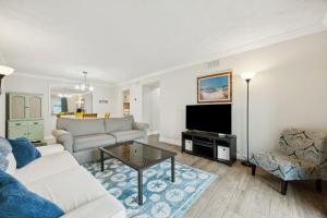 a living room with a couch and a tv at Chill by The Shores - Pet Friendly - Fernandina Beach in Fernandina Beach