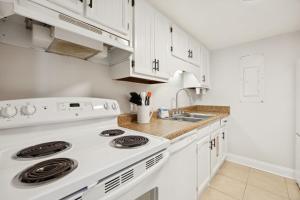 a kitchen with white cabinets and a white stove top oven at Chill by The Shores - Pet Friendly - Fernandina Beach in Fernandina Beach