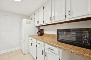 a kitchen with white cabinets and a microwave at Chill by The Shores - Pet Friendly - Fernandina Beach in Fernandina Beach +29 photos