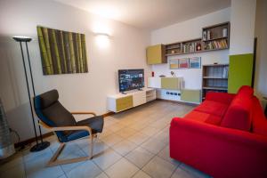 a living room with a red couch and a chair at Flat with terrace close to Forum and Milanofiori Metro in Assago