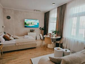a bedroom with two beds and a table and a dining room at Apartamenty Paryskie Old Town View in Toruń