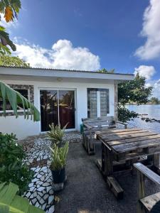 TaputapuapeaIsa Seaside的前面有桌子和长凳的房子