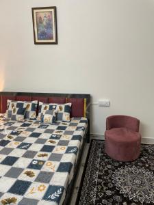 una camera da letto con un letto e una sedia di Atulyam villa near Lucknow junction a Lucknow