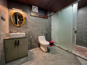 een badkamer met een toilet, een wastafel en een spiegel bij YOLO Outdoors - Riverside Luxury Domes, Jispa in Jispa +54 foto's