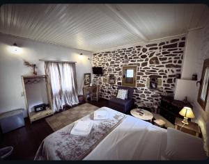 ein Schlafzimmer mit einem Bett und einer Steinwand in der Unterkunft Castle Rizaraki in Kokkala