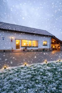 VaideeniCasuta din Deal的前面的地面上积雪的房子