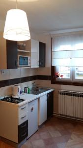 uma cozinha com um lavatório e um fogão forno superior em Apartmani Stonewood em Zagreb