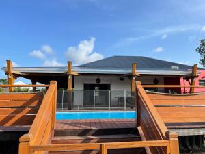a house with a deck and a swimming pool at Villa fleurs d'Antalia in Anse-Bertrand
