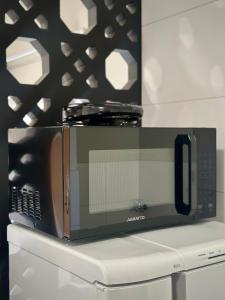 een magnetron met een koelkast bij Apartamento Palmeira Essencial in Formosa +16 foto's