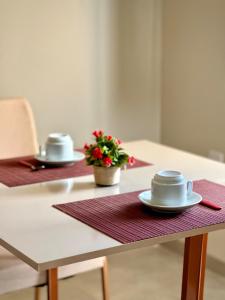 een tafel met twee platen en een plant erop bij Apartamento Palmeira Essencial in Formosa