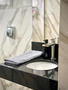 een badkamer met een wastafel en een spiegel bij Apartamento Palmeira Essencial in Formosa