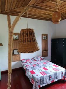 een slaapkamer met een bed en een kroonluchter bij Koniminto in Pijao