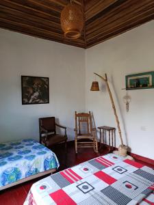 een slaapkamer met 2 bedden en een lamp en een stoel bij Koniminto in Pijao +14 foto's