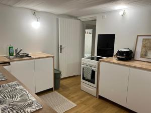 een keuken met witte kasten en een kookplaat oven bij Rez-de-jardin cozy in Houilles