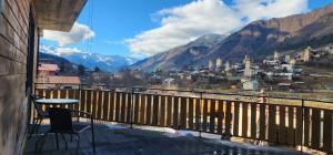 een tafel en stoel op een balkon met uitzicht over de stad bij hotel "Riverside Mestia" in Mestia +10 foto's