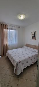 een slaapkamer met een bed met een deken erop bij Luminoso e accogliente in Cortona