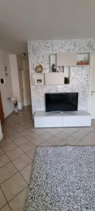 een woonkamer met een bank en een tv bij Luminoso e accogliente in Cortona