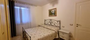 een kleine slaapkamer met een bed en een raam bij Luminoso e accogliente in Cortona