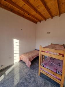 a bedroom with two bunk beds and a wooden ceiling at El Solar in San Antonio Oeste