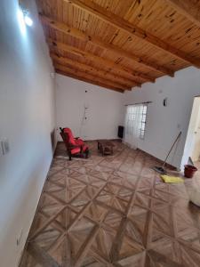 a room with a red chair and a wooden ceiling at El Solar in San Antonio Oeste