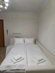 a white bed with two towels on top of it at Searea House in Perea