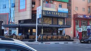 ein Restaurant mit Tischen und Stühlen in einer Stadtstraße in der Unterkunft Happiness Apartment in Ouarzazate