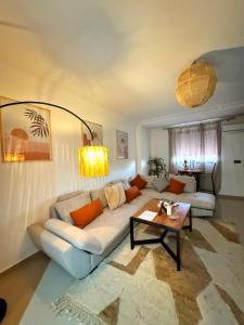 ein Wohnzimmer mit einer weißen Couch und einem Tisch in der Unterkunft Happiness Apartment in Ouarzazate