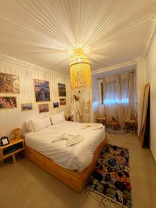 ein Schlafzimmer mit einem großen Bett und einem Kronleuchter in der Unterkunft Happiness Apartment in Ouarzazate