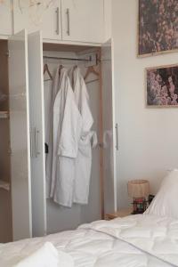 ein Schlafzimmer mit einem Bett und einem Schrank mit weißer Kleidung in der Unterkunft Happiness Apartment in Ouarzazate